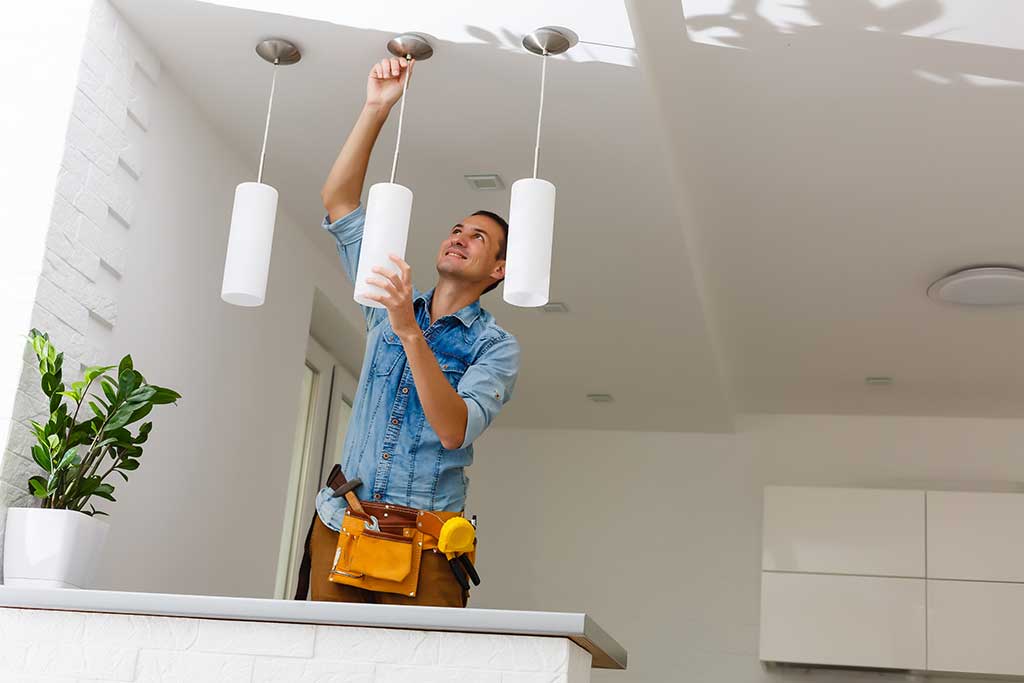 picture of a man installing lights into the ceiling